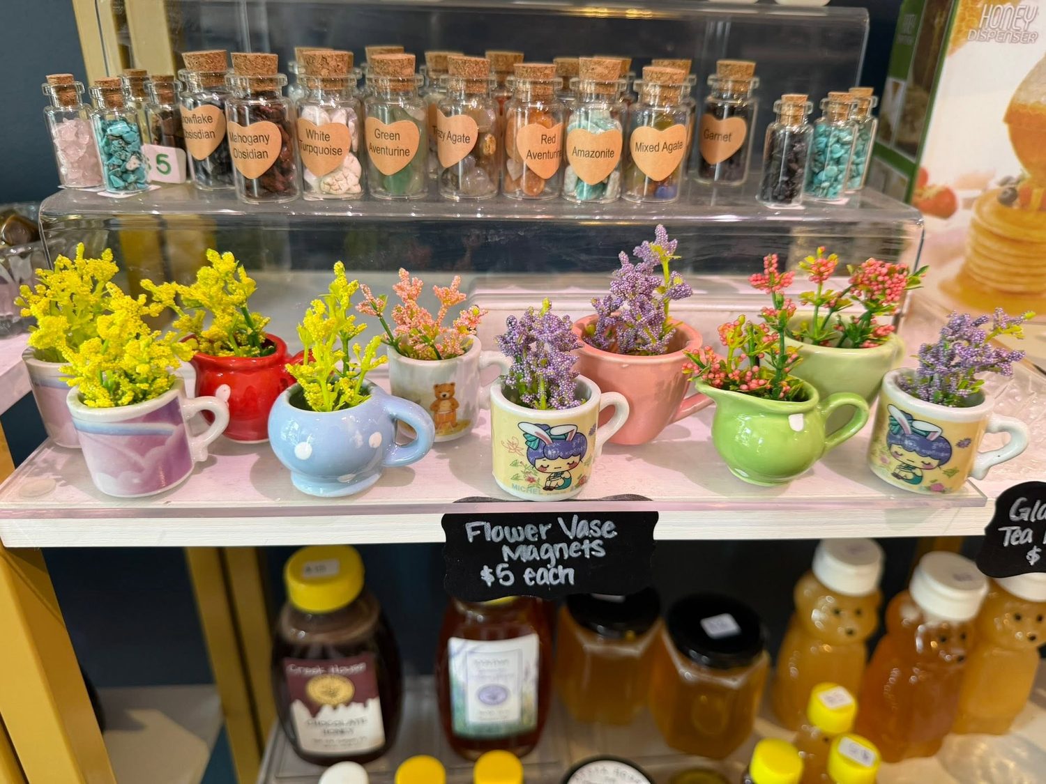 Small crystal chip vials and flower vase magnet mugs on display
