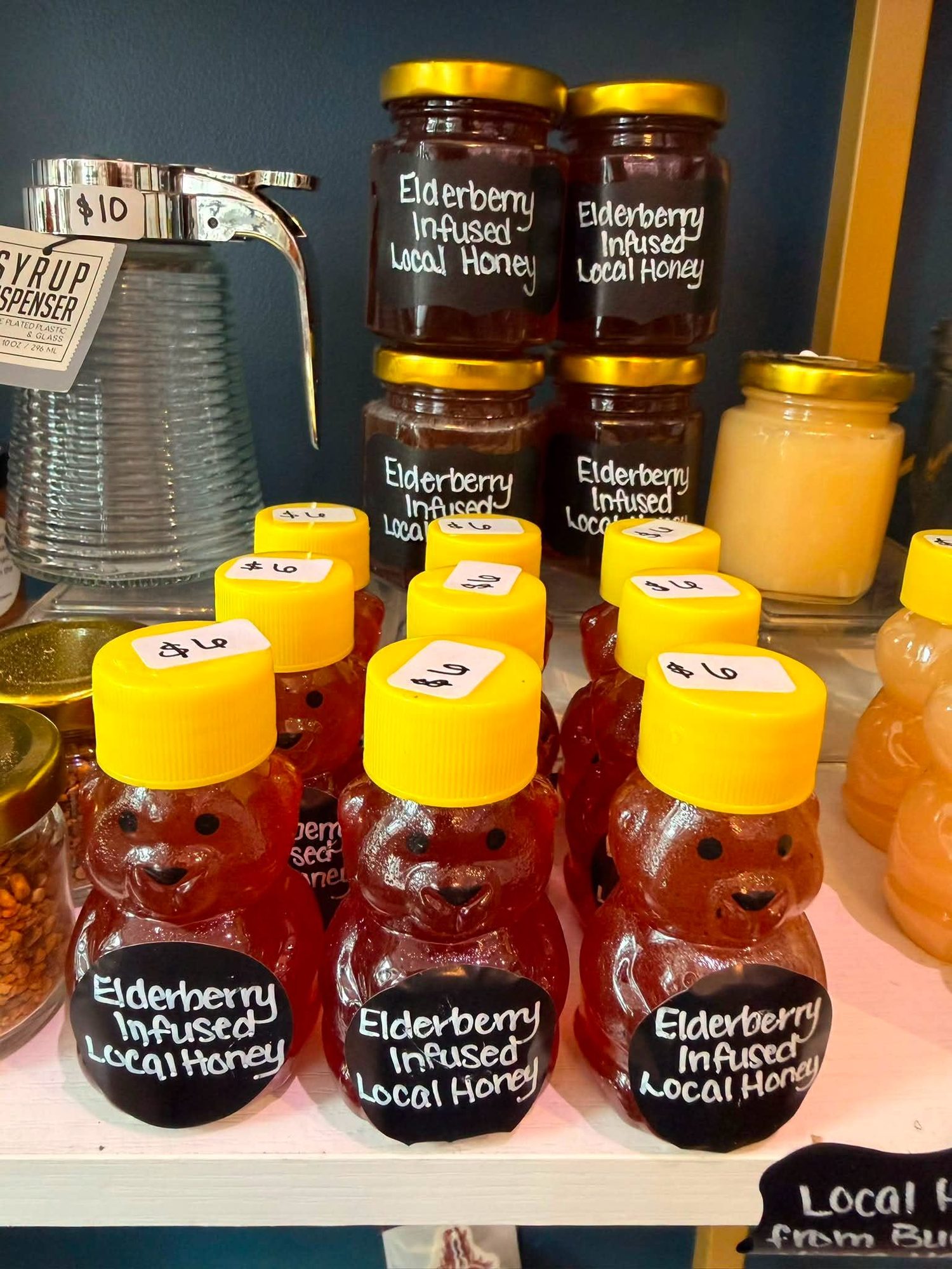 Jars and honey-bear bottles of elderberry infused local honey